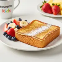 Kids French Toast from the First Watch Breakfast Menu with Prices, served with powdered sugar and a side of fresh fruit.
