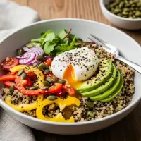 Power Breakfast Quinoa Bowl from the First Watch Menu, featuring quinoa, Italian sausage, mushrooms, tomatoes, kale, and Parmesan, topped with two cage-free eggs.